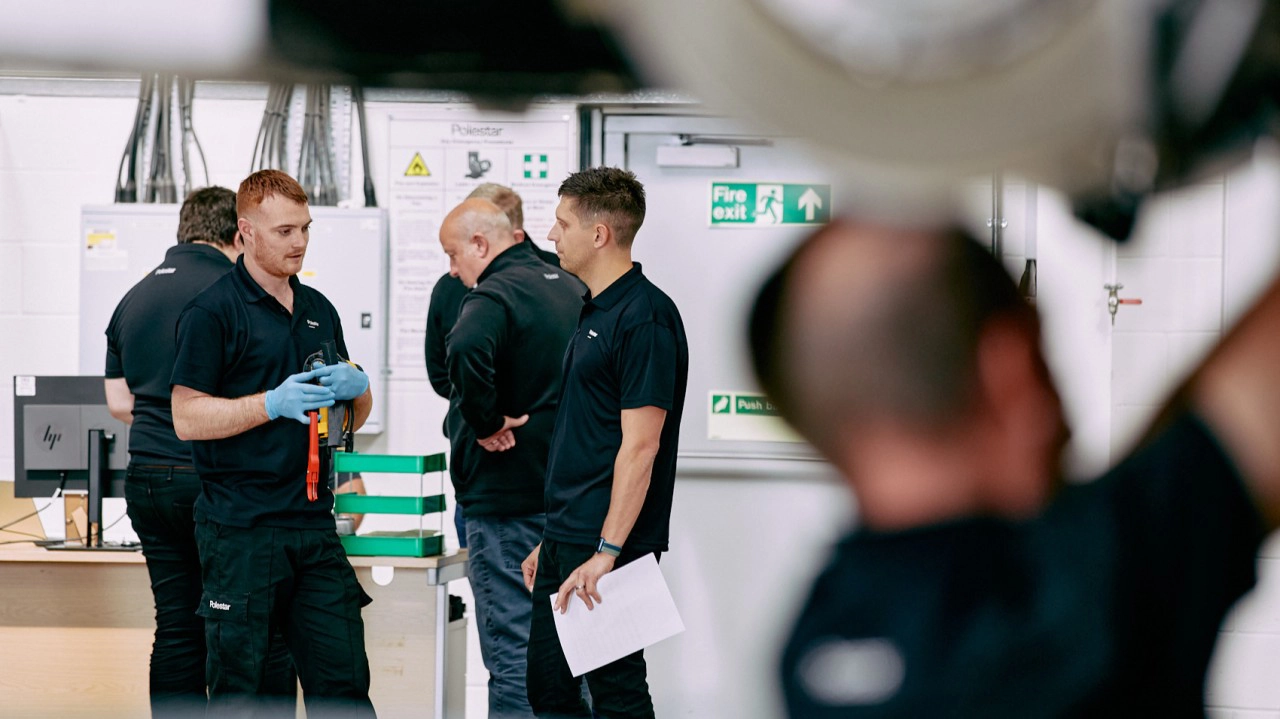 A group of men chatting in a car workshop